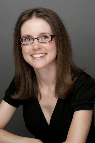 smiling young woman with brown shoulder length hair and glasses